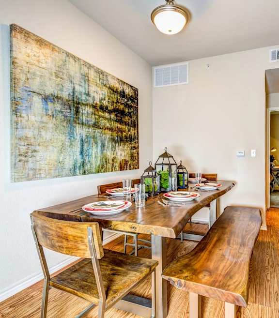 a dining room with a table and chairs and a painting on the wall