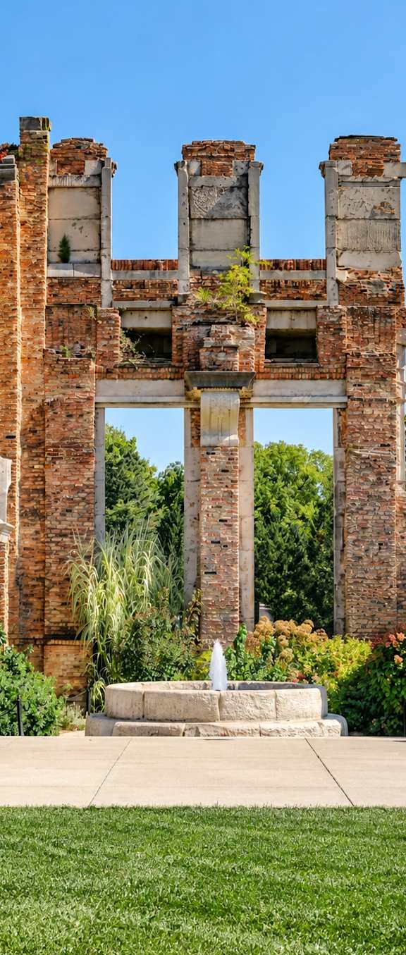 A large brick structure with a fountain in front of it.