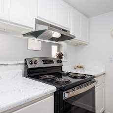 kitchen with a black stove top oven and white cabinets.