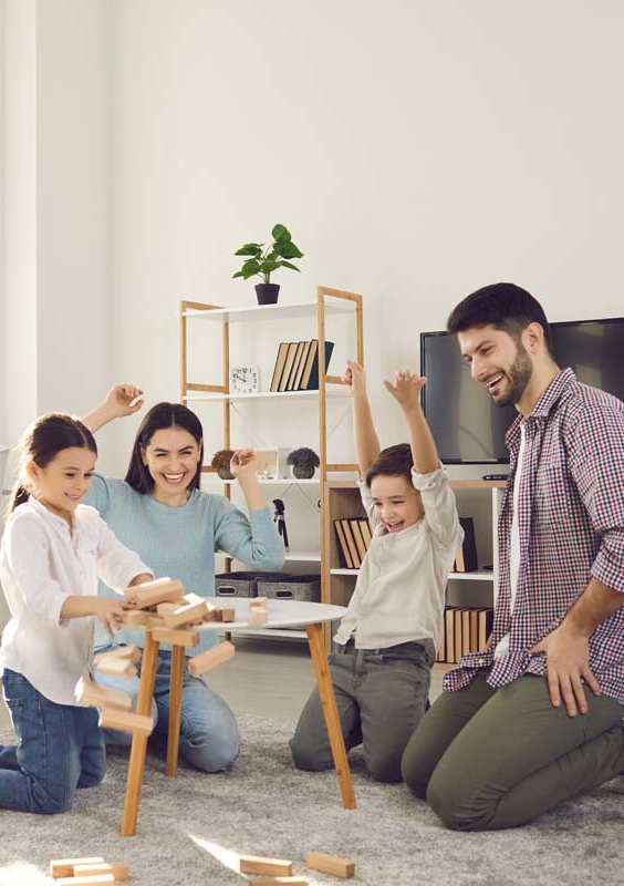 A family is playing a game on the floor in a room.