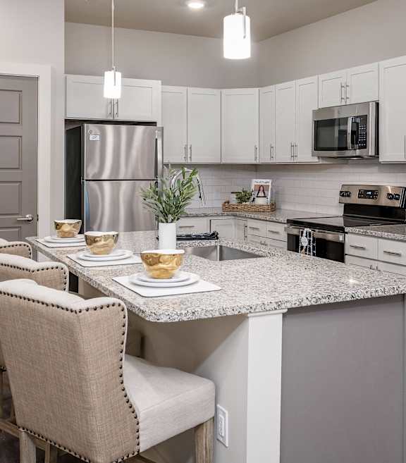 an open kitchen and dining area with a marble counter top