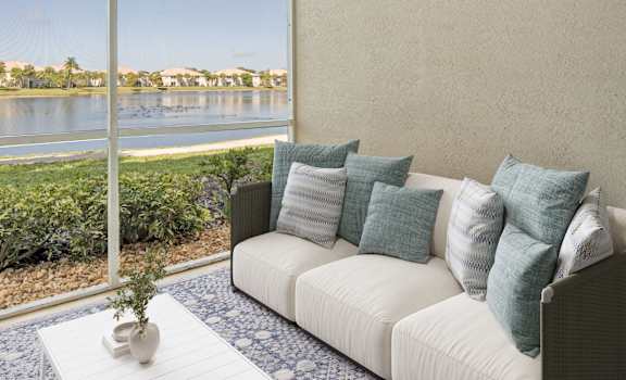 A living room with a couch and a view of a lake through the window.