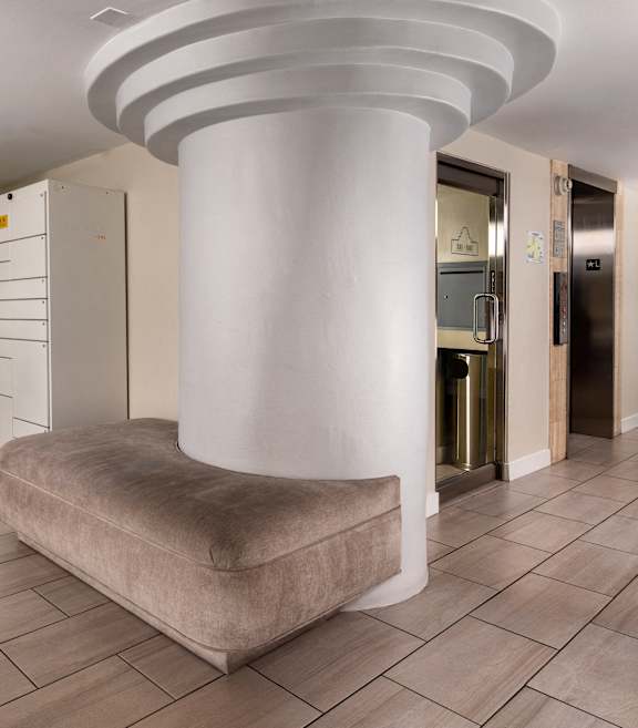 a lobby with a large pillar in the middle of it