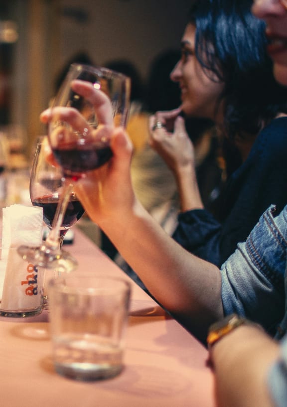 a group of people sitting around a table with wine glasses
