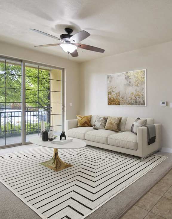 A living room with a white couch and a rug with a black and white pattern. at Siena Villas Apartments, Orem, UT