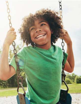 A child is swinging on a swing in a park.