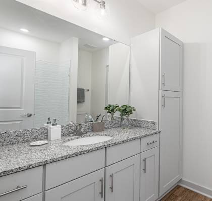 A bathroom with a sink, mirror, and cabinets. at Allier Port Wentworth Apartments, Port Wentworth, Georgia