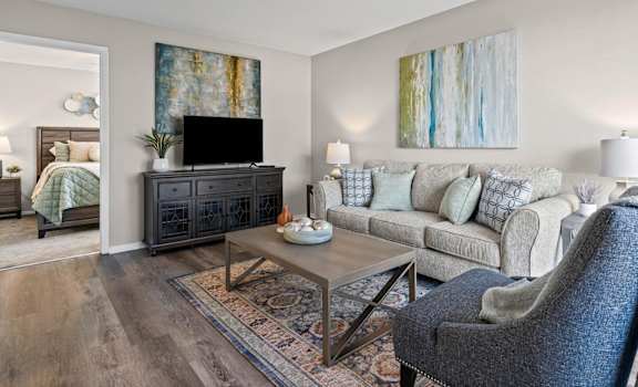 A living room with a grey chair and a black cabinet.