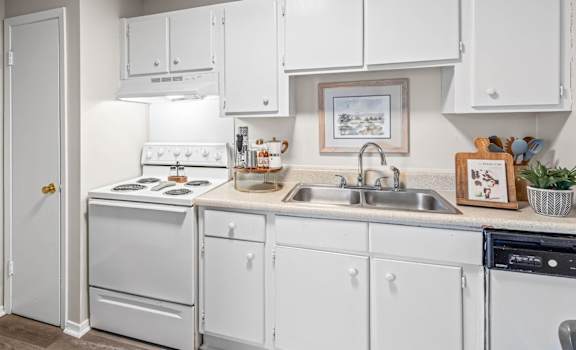 A kitchen with white appliances and cabinets.