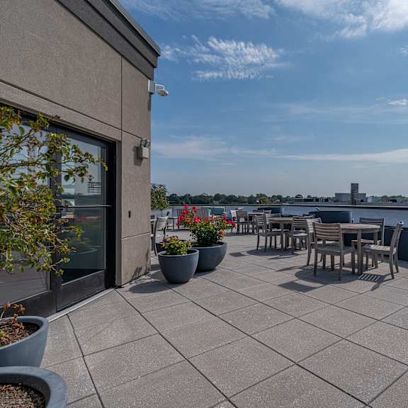 A patio with a table and chairs overlooking a body of water.
