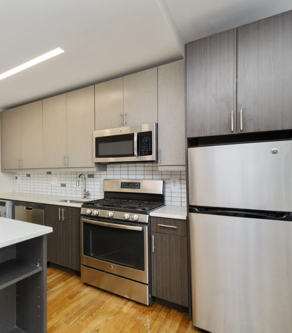 a kitchen with white countertops and stainless steel appliances