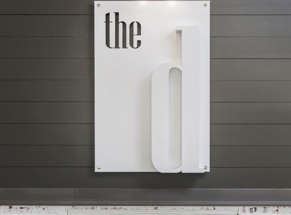 a sign that says the on it in front of a wall with black shiplap