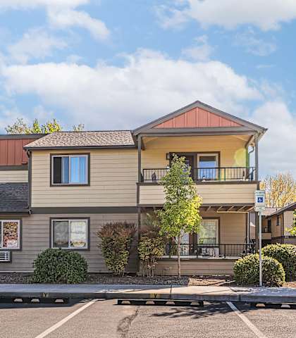 A two-story building with a parking lot in front.