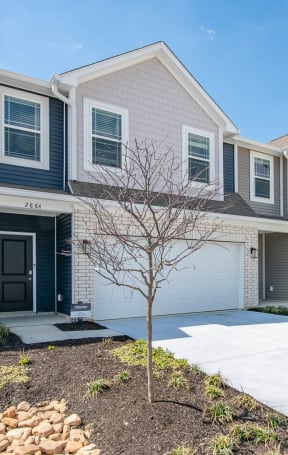 a row of town homes with garages and a driveway at Jackson Run Townhomes, Whitestown