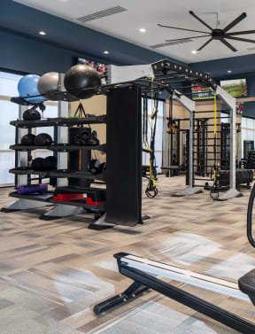 a spacious fitness room with cardio equipment and weights
