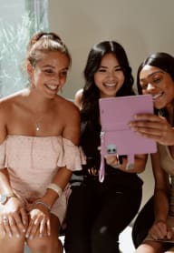 three women sitting on a couch looking at a tablet at The Lodge at Madrona, Washington