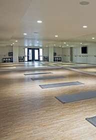 A yoga studio with wooden floors and mirrors on the wall.