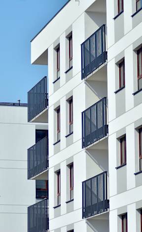 A white building with black railings and yellow accents.