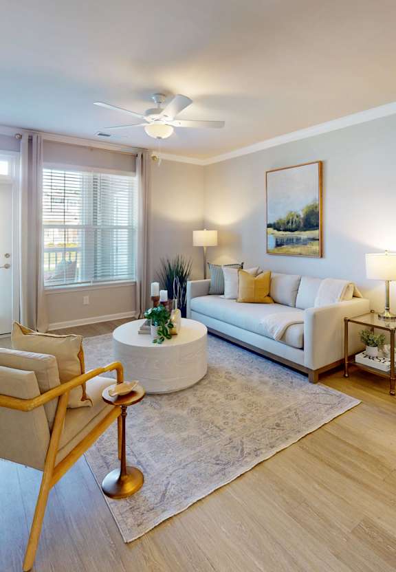 A living room with a couch, chair, and potted plant.
