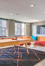 A room with a pool table and a couch.