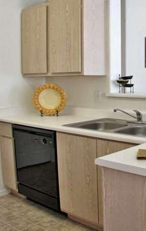 A kitchen with a black oven and wooden cabinets.