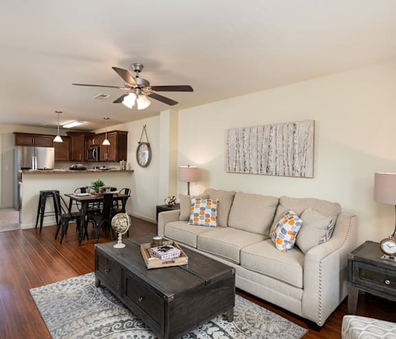 A living room with a couch, coffee table, and a ceiling fan.