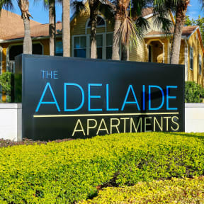 the adelaide apartments sign in front of palm trees