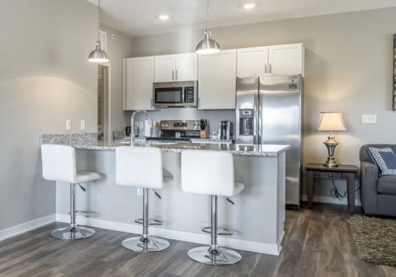 Kitchen with barstools and warm lighting for a cozy, functional setup.