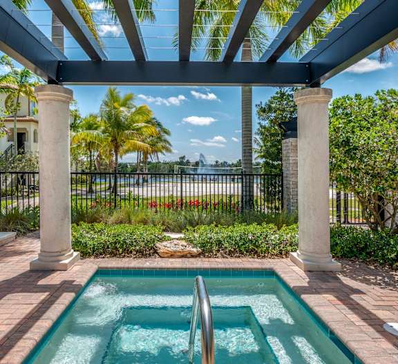 A pool surrounded by a black fence and a white pillar.