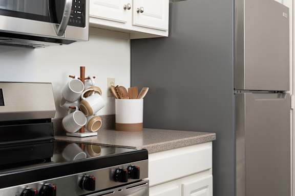 A modern kitchen with a stove top and a refrigerator at The Bosk Apartment Homes, Woodbury, Minnesota