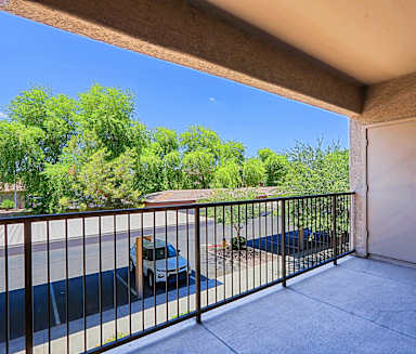 a balcony with a gate and a car parked on the street