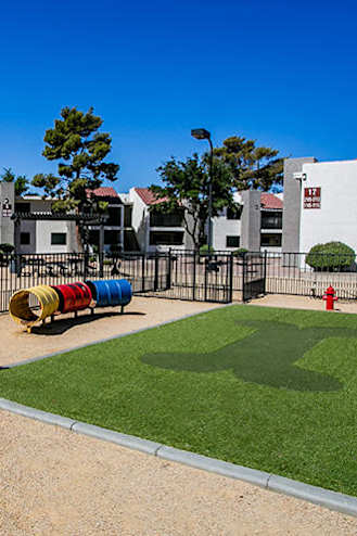 a playground in a fenced in area with a slide