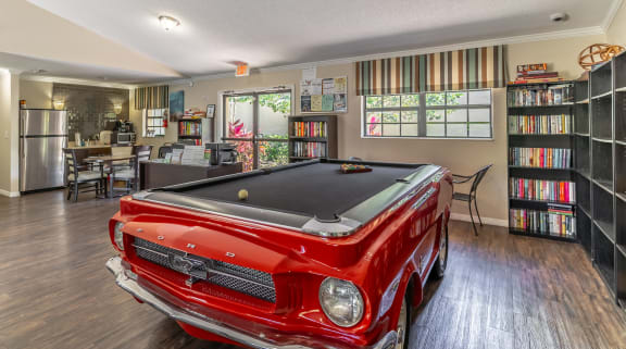 a game room with a pool table and bookshelves