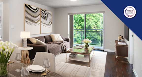 A dining room with a table set for six and a couch in the background.
