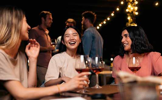 A group of people are enjoying drinks together at a bar.