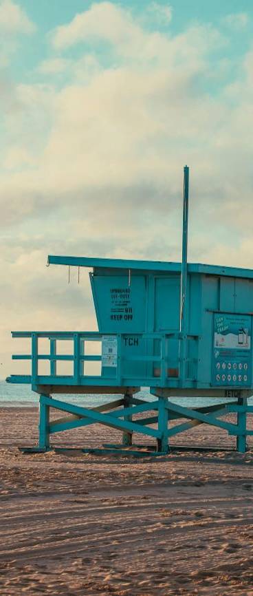 A lifeguard tower stands on a sandy beach.