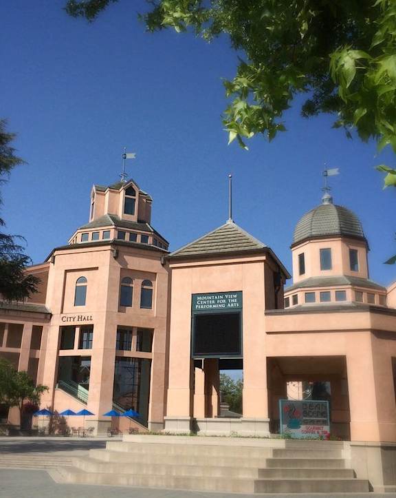 A pink building with a sign that says City Hall.