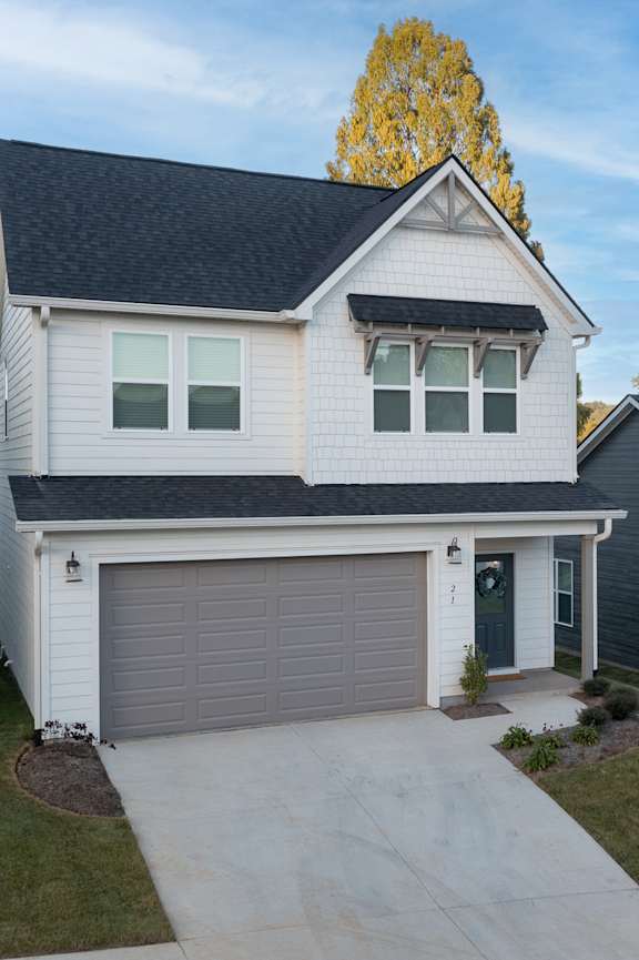 A two-story house with a garage and a driveway.