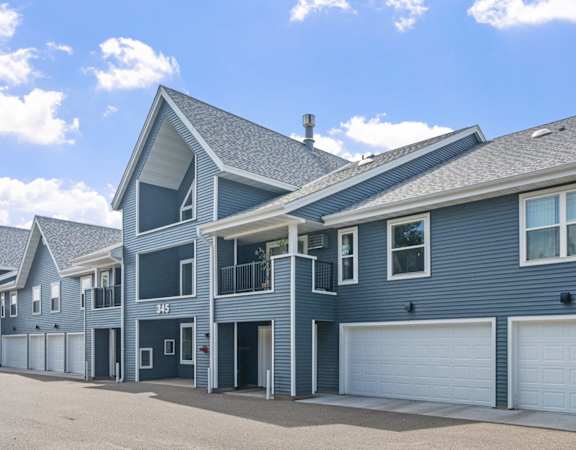 A row of houses with garages and driveways.
