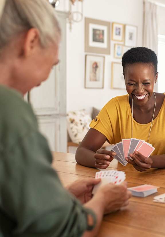A group of people playing a card game at a table.