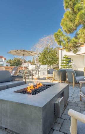 a patio with couches chairs and a fire pit at The Resort at Encinitas Luxury Apartment Homes, Encinitas