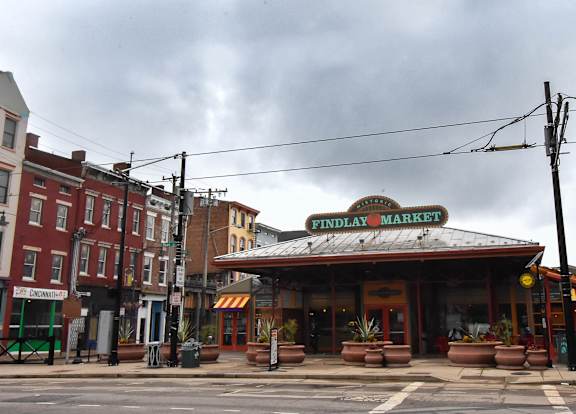 A street view of a market with a sign that says "FINDLAY MARKET".