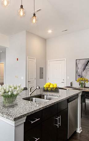 an open kitchen with a granite counter top and stools