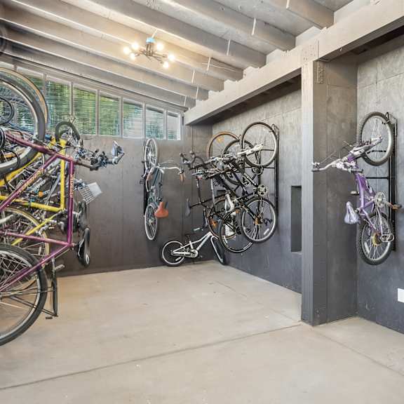 A bike room with many bikes hanging on the wall.