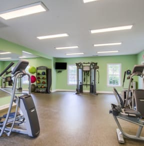 a gym with cardio equipment and weights