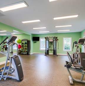 a gym with cardio equipment and weights