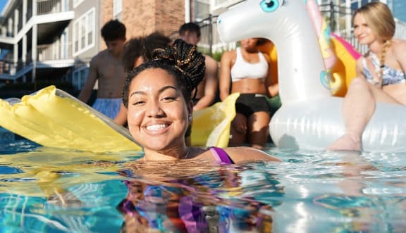 a woman swimming in a pool with an inflatable unicorn float