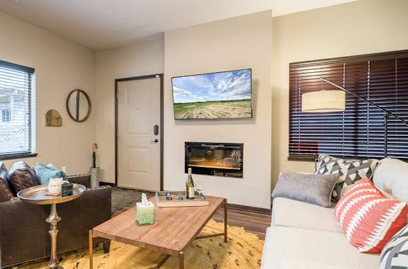 A living room with a fireplace and a painting on the wall.