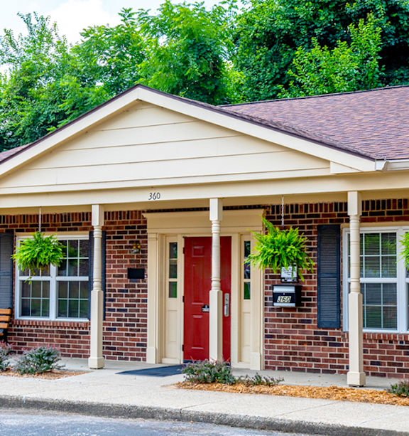 A house with a red door and a mailbox on the right side.