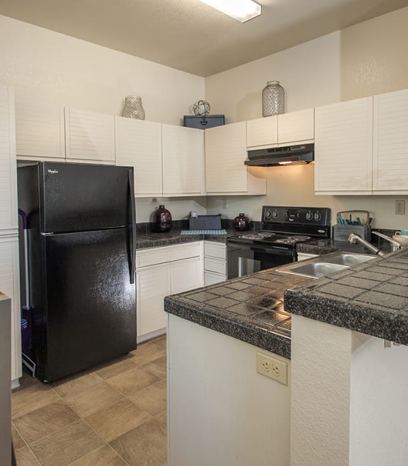 Autumn Oaks apartments model kitchen with black appliances and white cabinets at Autumn Oaks Apartments, California, 95678